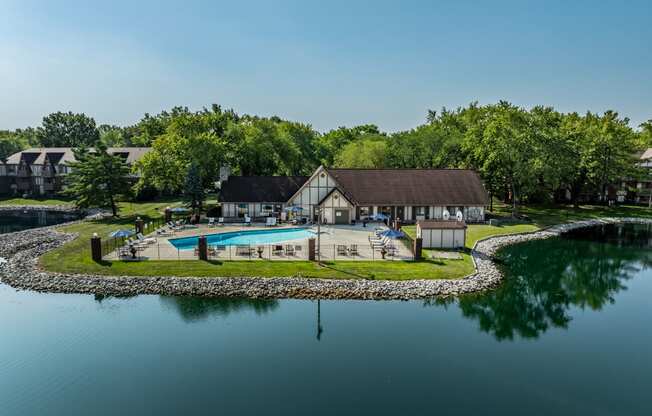 a backyard with a pool and a house next to a lake