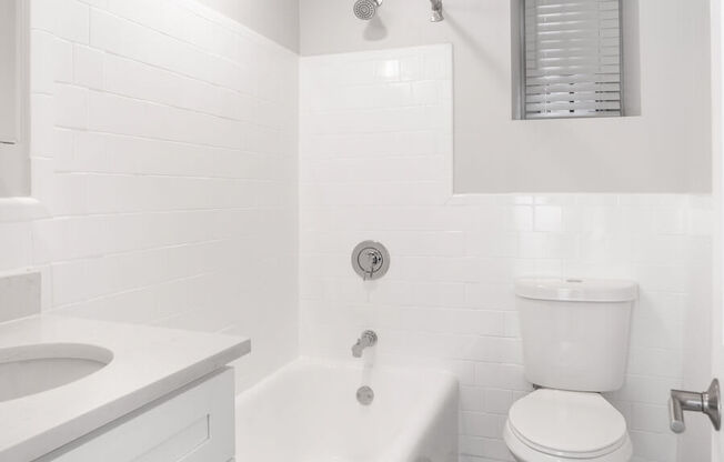 white bathroom with a toilet and a tub