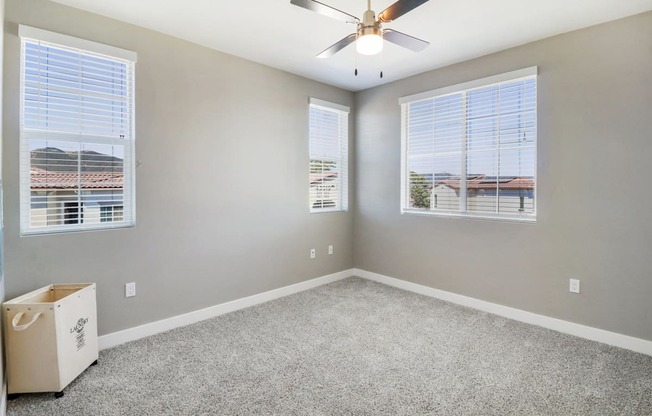 Bedroom with ceiling fan and windows at Arrive Temecula