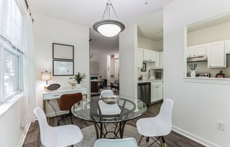 an open living room and dining room with a glass table and chairs
