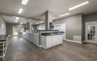 a community room with a kitchen and a counter top in the middle