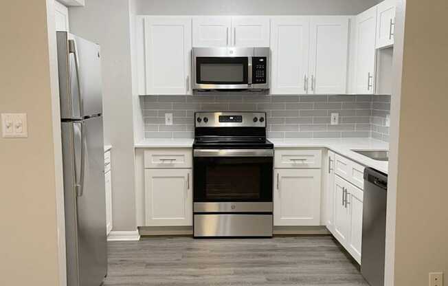 a kitchen with stainless steel appliances and white cabinets