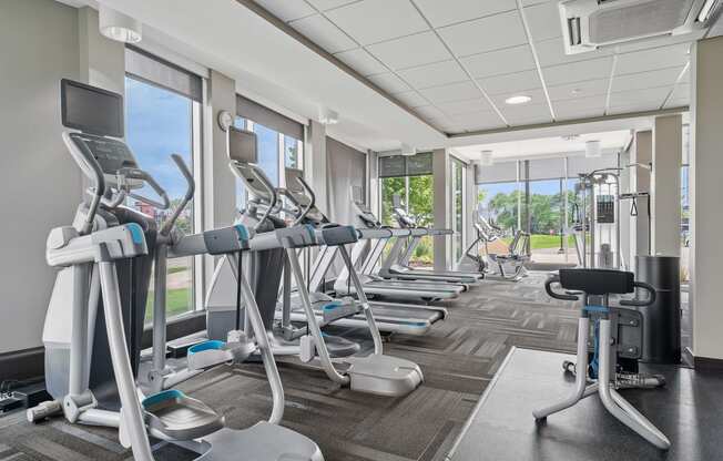 a room filled with cardio equipment and a large window