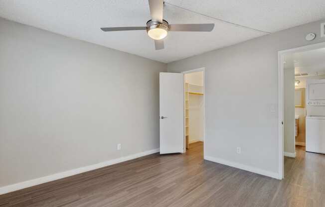 the living room of an empty apartment with a ceiling fan