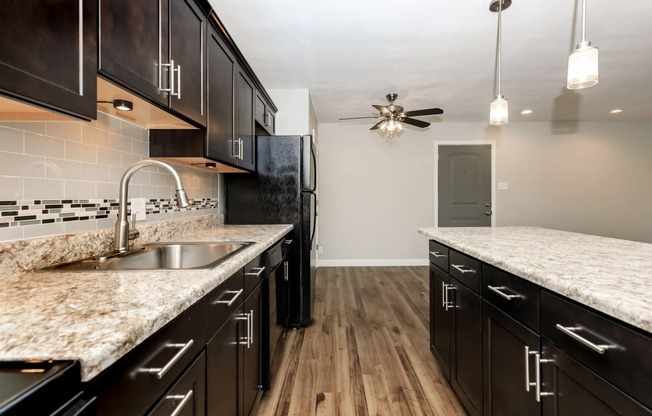 a kitchen with dark cabinets and white countertops