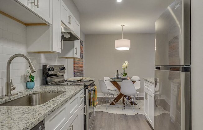 a kitchen with a sink and a table with chairs