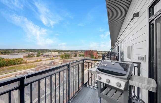 the balcony has a grill and a view of the city