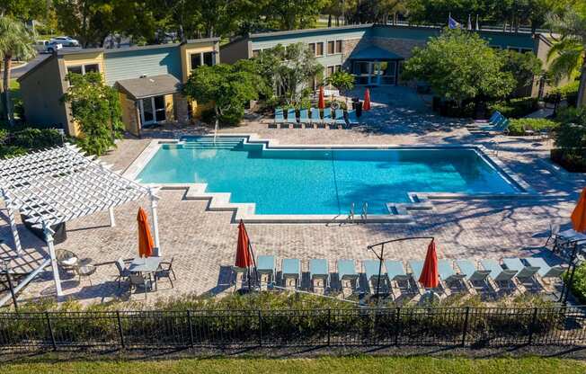 a pool with chairs and umbrellas and a swimming pool