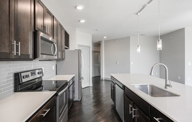 a renovated kitchen with white counter tops and dark wood cabinets