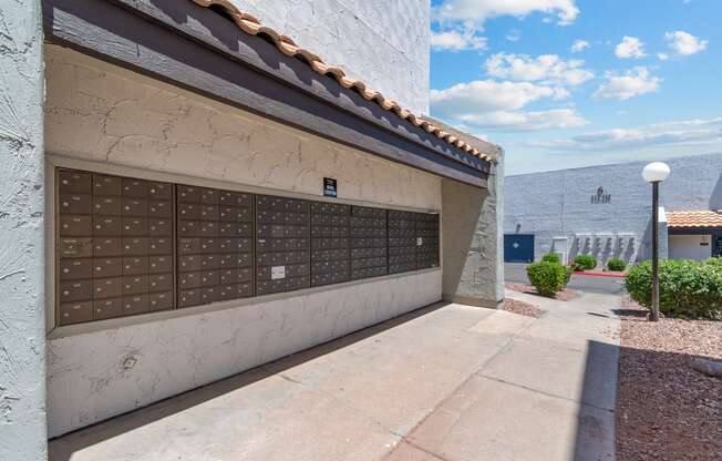 a garage with a white wall and tile roof with a blue sky in the background