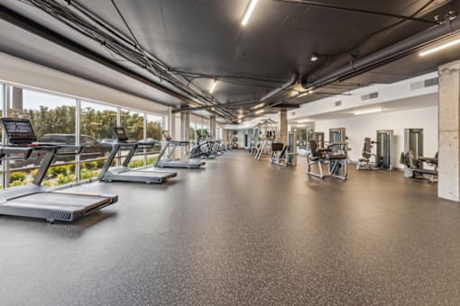 A gym with treadmills and other exercise equipment at The Waterford At Rocketts Landing Apartments, PRG Real Estate, Richmond, Virginia