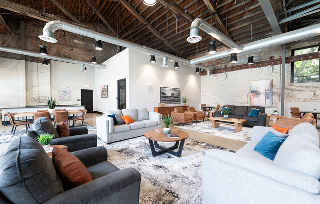 Modern loft-style dining and kitchen area with exposed brick