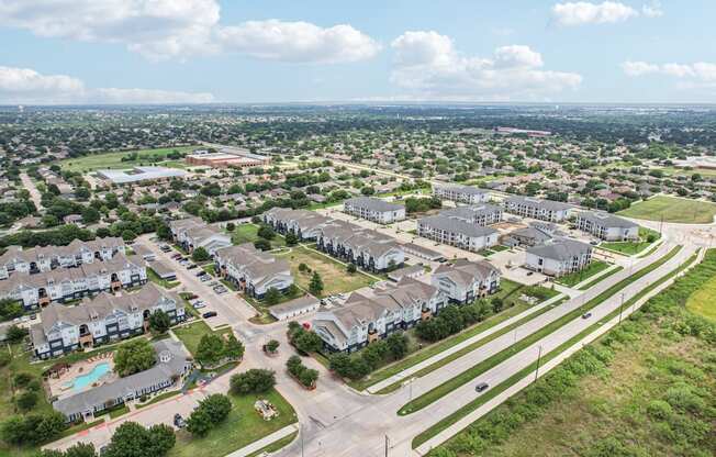 A suburban neighborhood with apartment buildings and a road with a median.