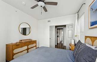 A bedroom with a bed, dresser, and mirror.