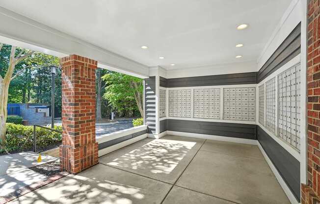 A sunny day at a house with a brick pillar and a white wall.