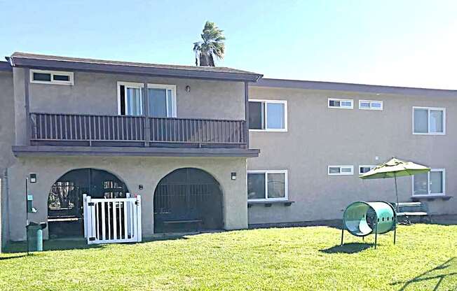 A building with a balcony and a white fence in front of it.