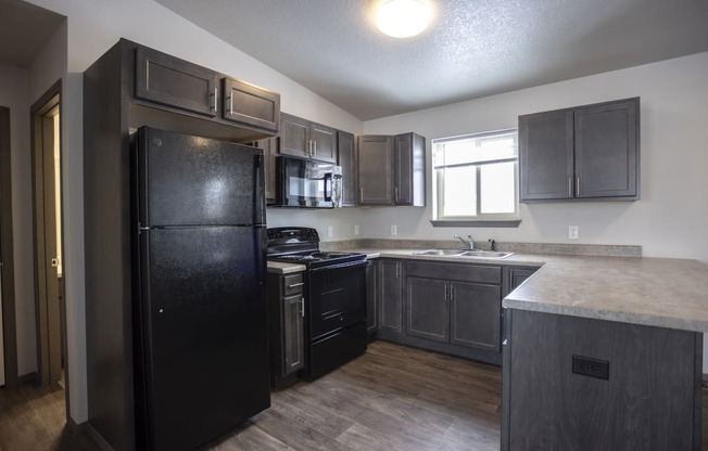 Modern open-concept kitchen and living area with black appliances.