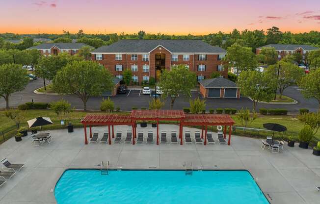an aerial view of a swimming pool with a hotel in the background