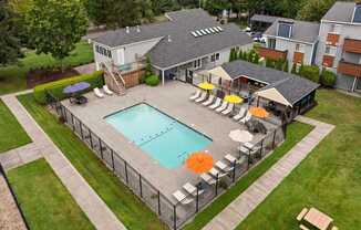 A pool surrounded by a fence and chairs. at Northpoint Apartments, Tacoma
