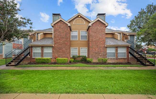 A brick house with a green lawn in front.