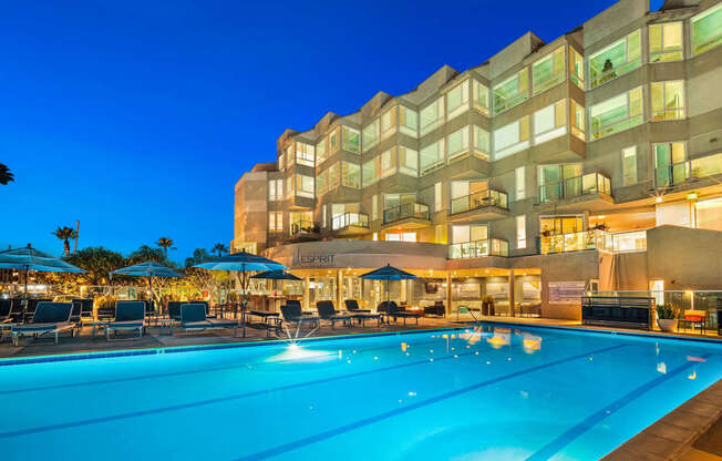A large pool in front of a building with a sign that says at Esprit Marina del Rey, 90292