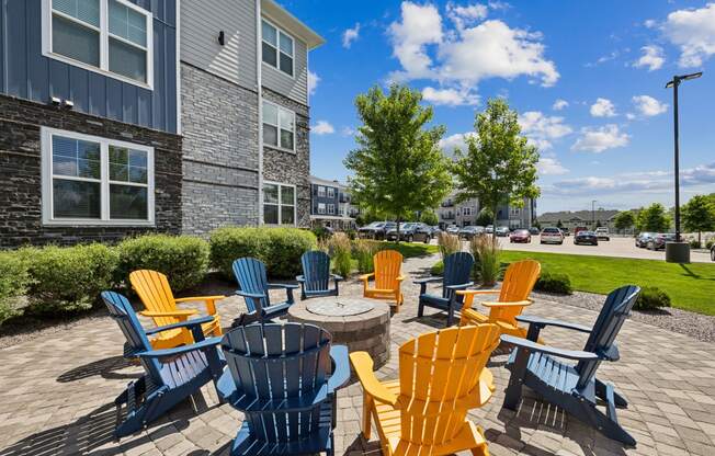 an outdoor patio with colorful chairs and a fire pit