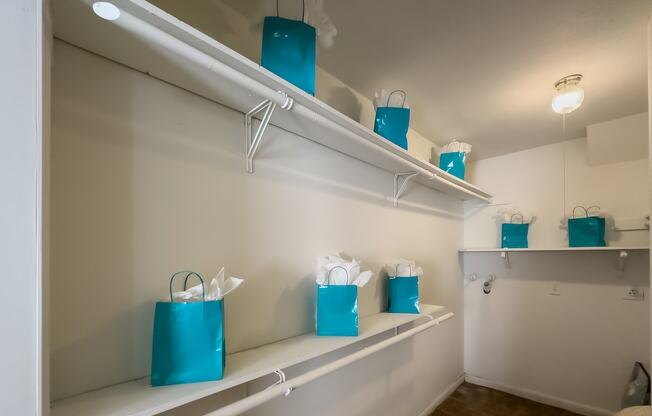 a room with white shelving and blue bags on the shelves