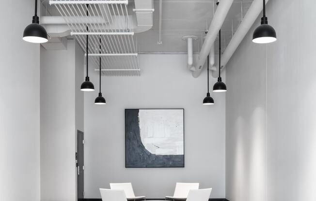 a conference room with white chairs and a table and ceiling lights at Maven on Broadway, Rochester, MN, 55904