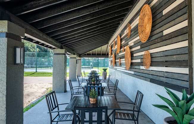 outdoor seating area at Fusion Fort Worth Apartment complex in Haltom City, Texas with modern greyscale siding and black metal patio furniture