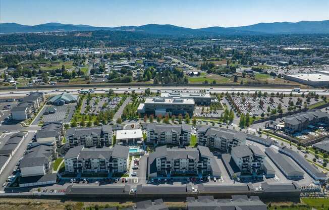 an aerial view of a suburb of a city with cars parked in a parking lot