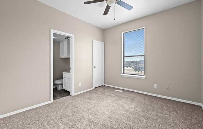 an empty room with a window and a ceiling fan at Diamond Ridge Townhomes, Oklahoma City, OK