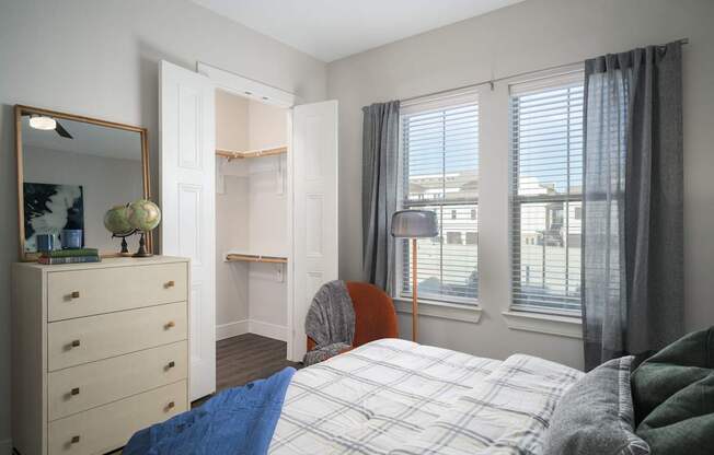 A bedroom with a bed, dresser, and window.