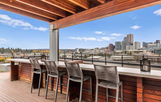 A wooden deck with chairs and a city view in the background.