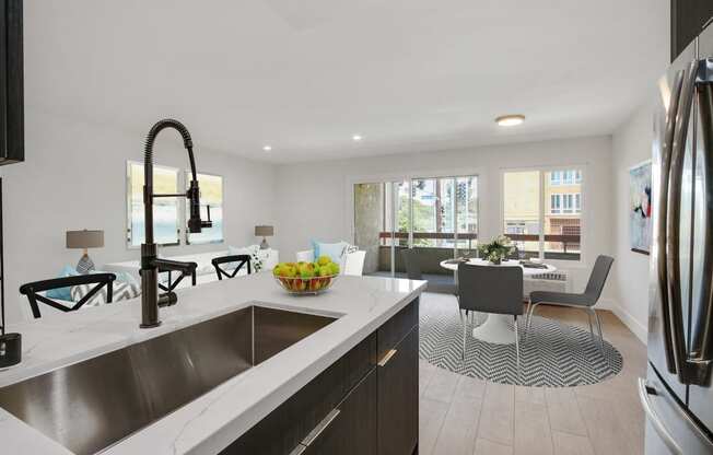 a kitchen and living room with a large counter top and a sink