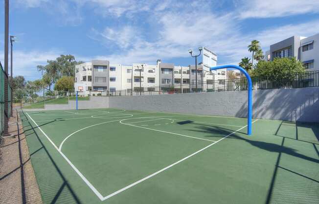 a green basketball court with buildings in the background at Vaseo Apartments, Phoenix, 85022