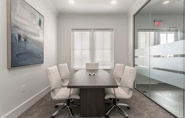 a conference room with a wooden table and white chairs