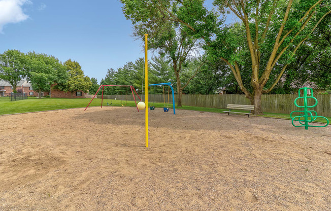 Playground at Ashley Pointe Apartments with swing sets, tetherball and climbing equipment