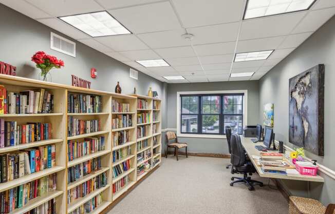 a library with shelves of books and a desk with a computer