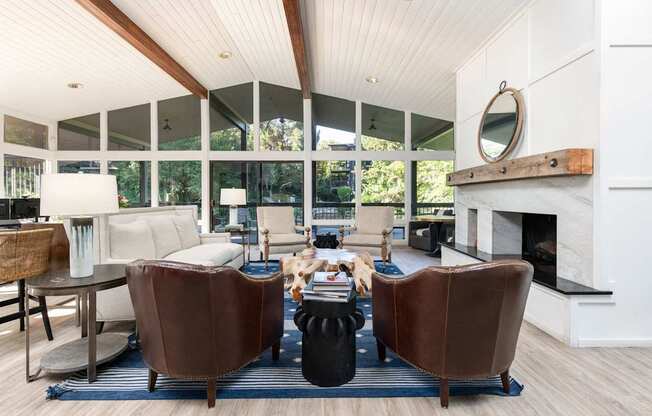 a living room with leather chairs and a fireplace