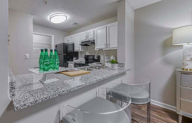 A kitchen with granite countertops and white cabinets.