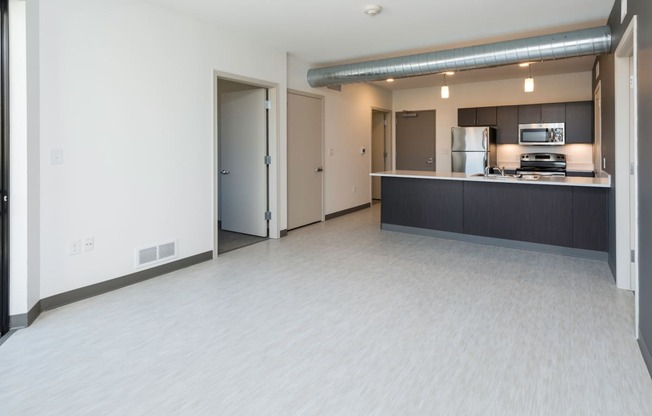 Modern open-concept kitchen and living area with stainless steel appliances.