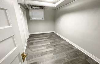 an empty room with wood floors and white walls