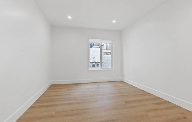 a living room with white walls and a window