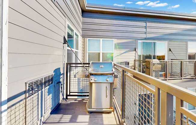 A balcony with a railing and a trash can.