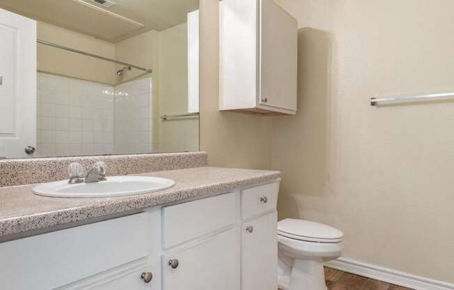 Bathroom with white cabinets and extra storage above the toilet