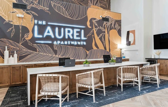 A conference room with a large table and chairs with a backdrop that says  at The Laurel Apartments, Chandler