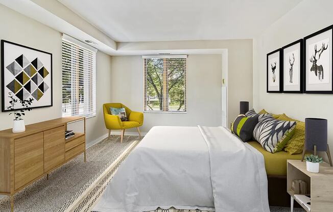 A bedroom with a large bed, a yellow chair, and a wooden dresser.