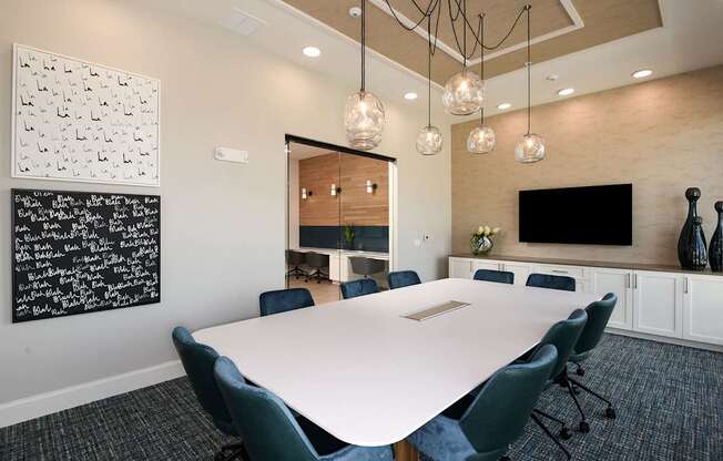 A conference room with a white table and blue chairs.
