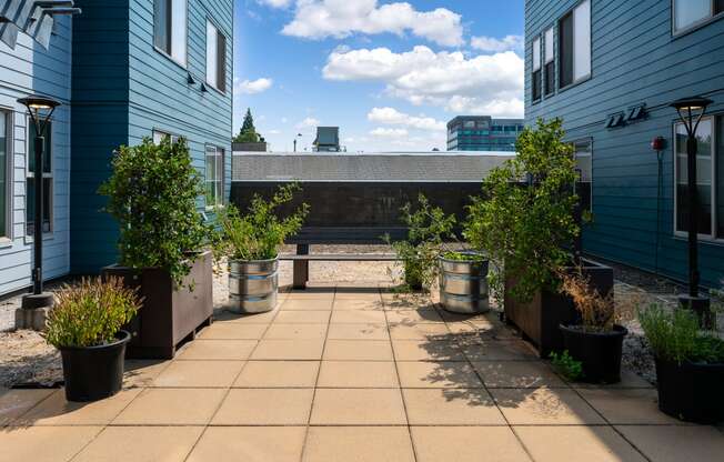 a patio with potted plants and a bench