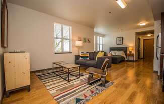 Portland OR Apartments - Corbett Heights Living Room in Our Studio Apartments With Cozy Decor and Hardwood-Style Floors